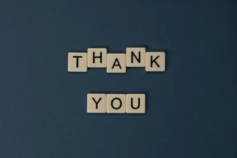 Wooden lettered tiles are arranged to read "thank you."